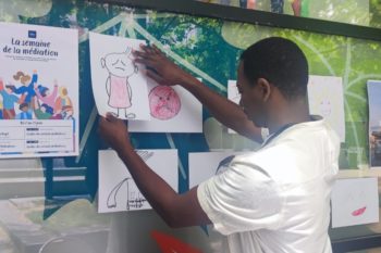 personne qui accroche des dessins