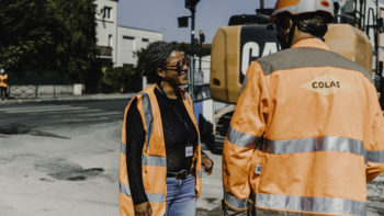 Médiatrice sur un chantier qui parle a un ouvrier