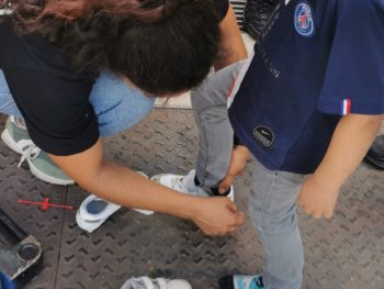 médiatrice qui aide un enfant a mettre ses chaussures