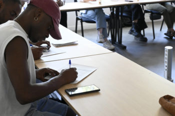 élève MSADS qui écrit sur une feuille